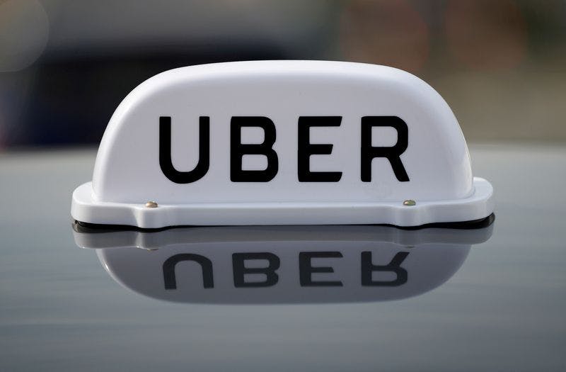 midia de mobilidade representada por placa da uber acima dos carros, como os taxis